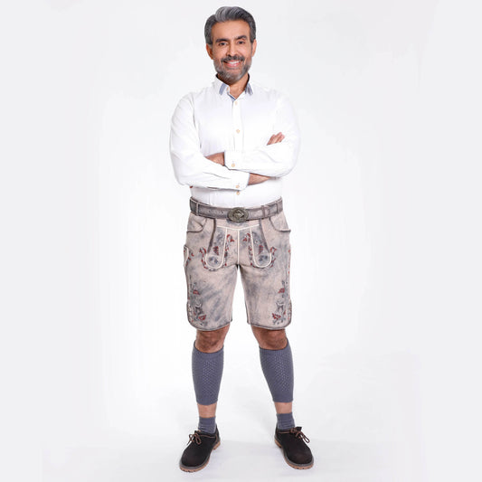 Embroidered light gray leather lederhosen shorts on a model with socks and dark shoes