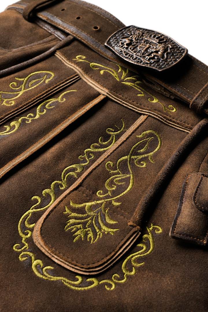 Brown leather lederhosen detail with green-gold embroidery panels and braided side trim