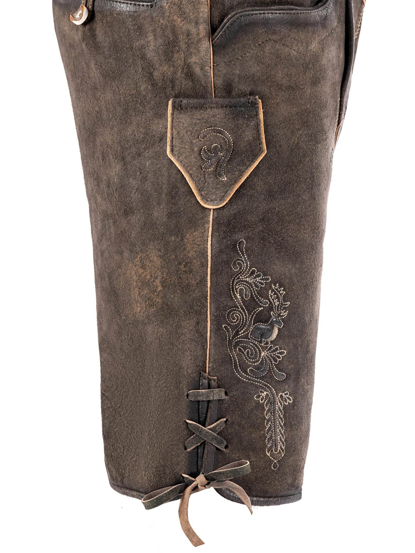 Men's dark brown traditional trousers close-up with decorative embroidery and laced hem ties