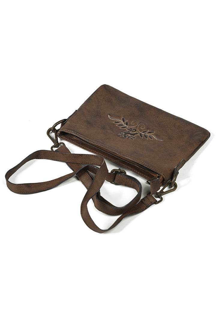 Brown suede-style small crossbody bag with white stitched crest and zip closure