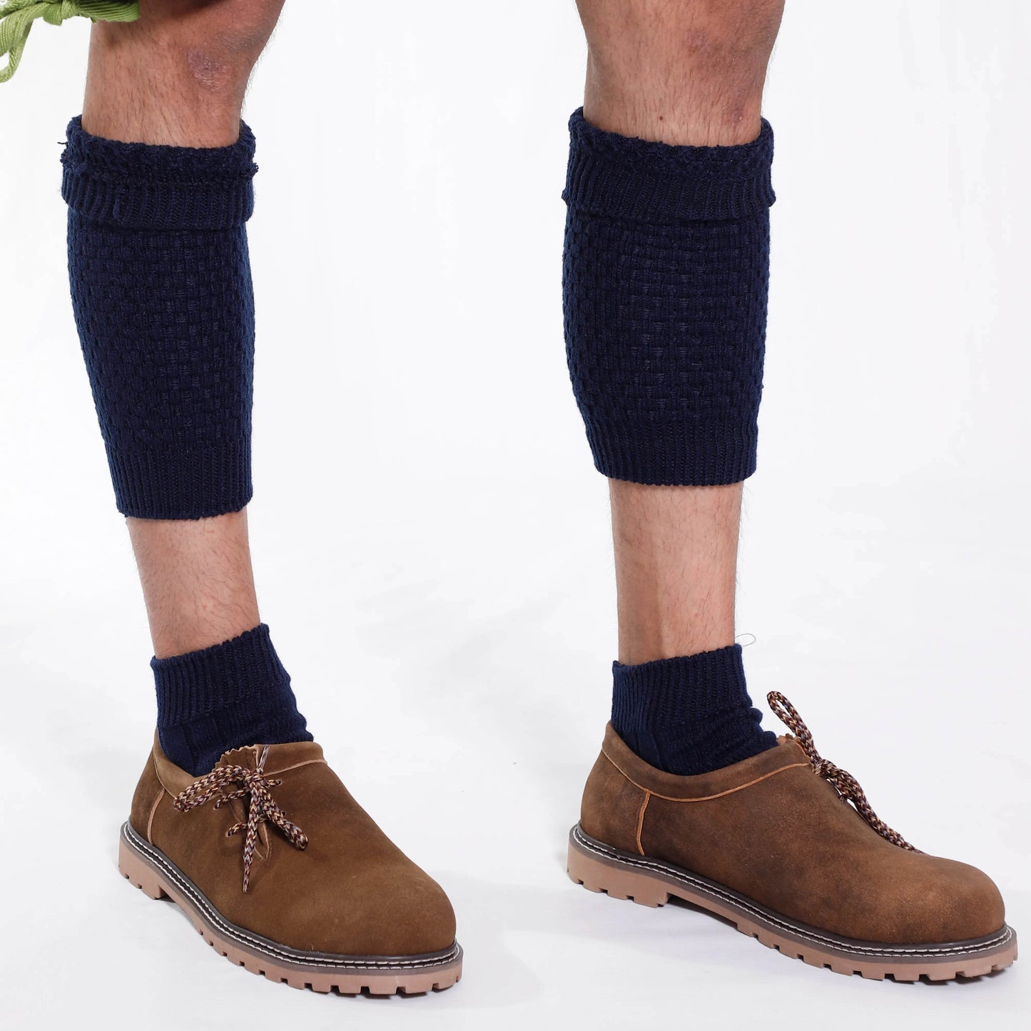 Dark blue knit high socks on men's legs with elastic cuff, worn with brown lace boots