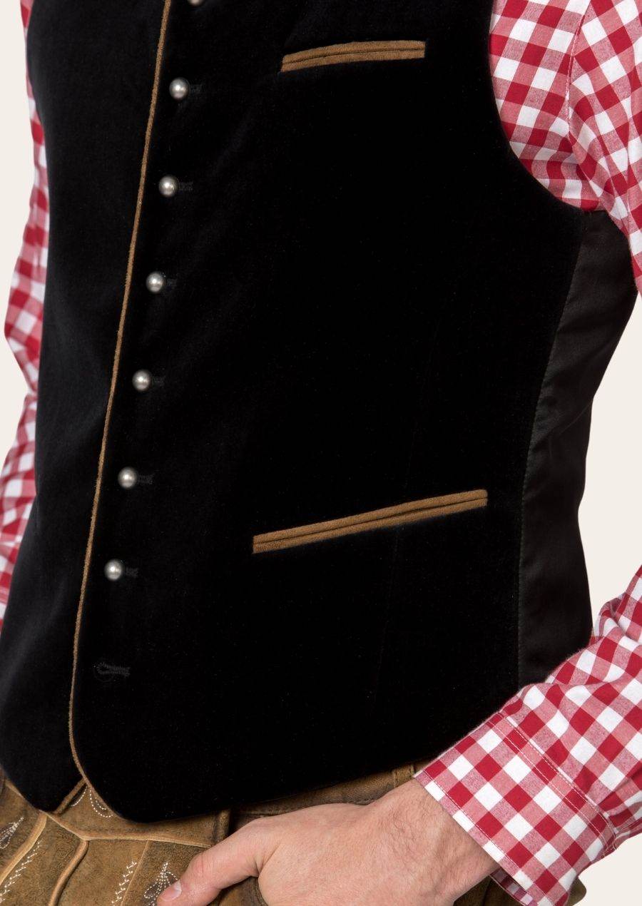 Close-up of black trachten waistcoat with standing collar, silver buttons, and brown trim