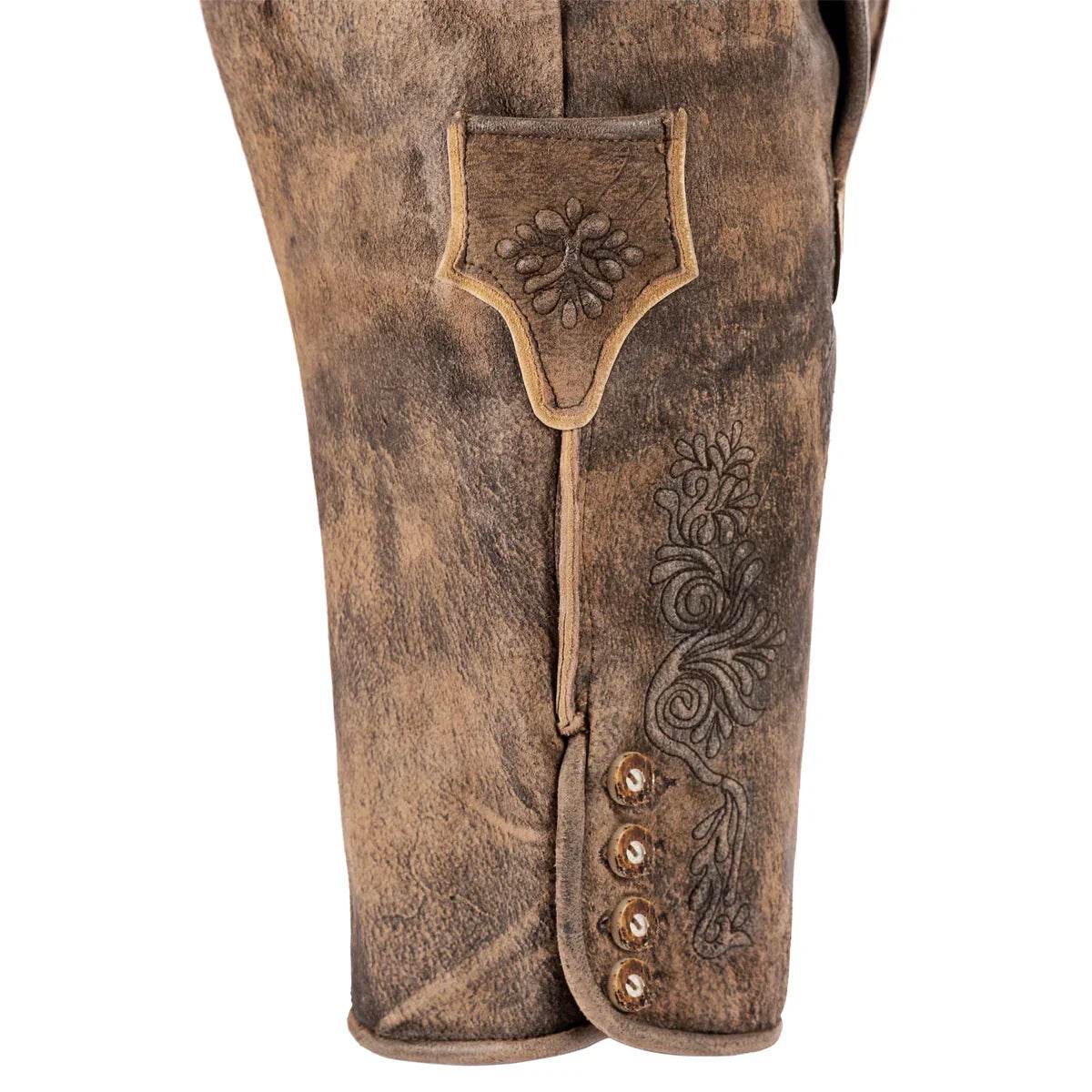 Close-up: men's brown leather lederhosen leg with embroidered patch and button placket