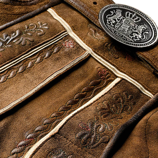 Dark brown short leather trousers close-up with ornate embroidery and white trim