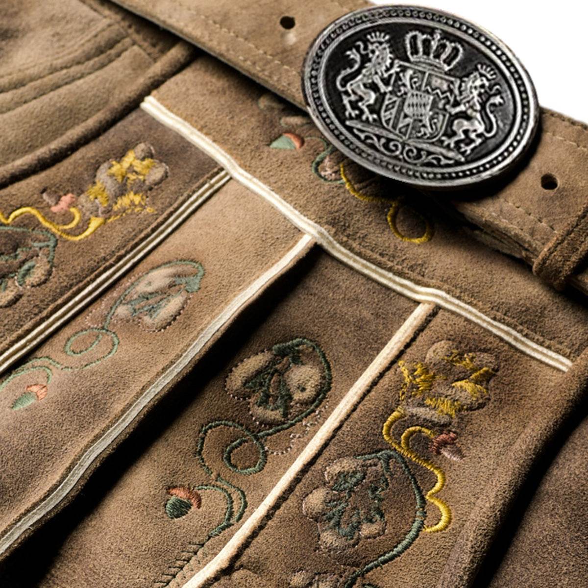 Brown leather lederhosen close-up: oval crest buckle and colorful embroidered trim