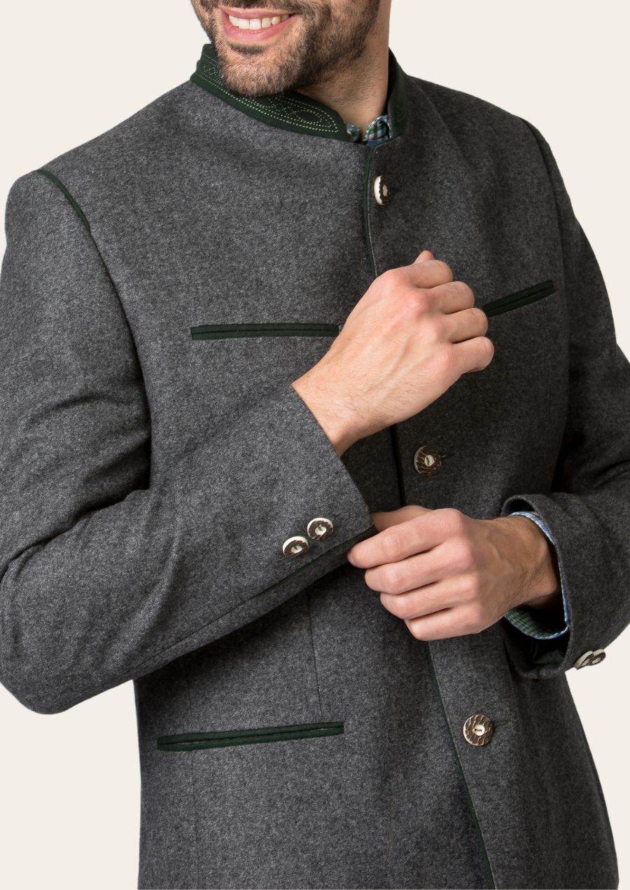 Men's traditional janker jacket close-up: dark gray with green-trimmed pockets and brass buttons