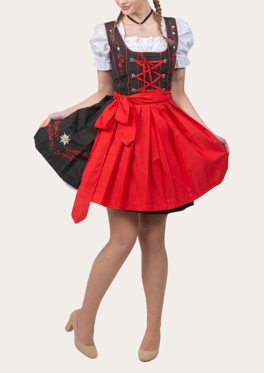 Dirndl dress worn with black apron and red skirt, white puff sleeves, red lace-up bodice