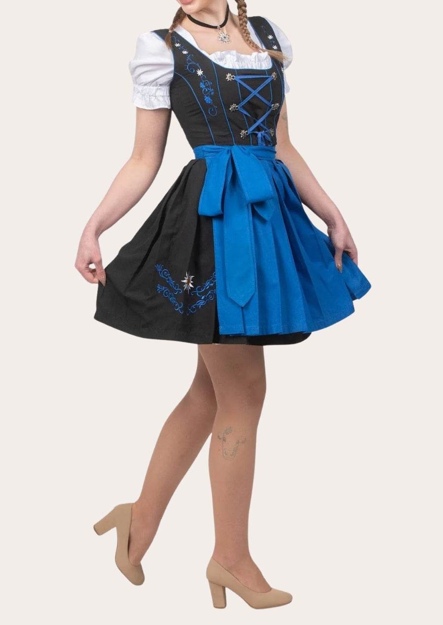Model-worn midi dirndl with two-tone skirt, blue waist bow, black apron panel, puff sleeves