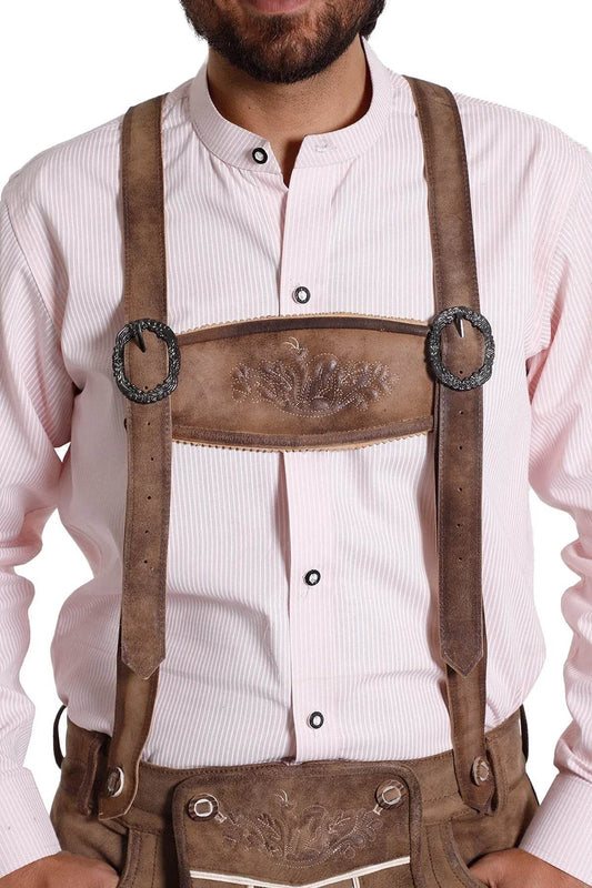 Decorative leather lederhosen suspenders worn over white shirt, embossed front bib