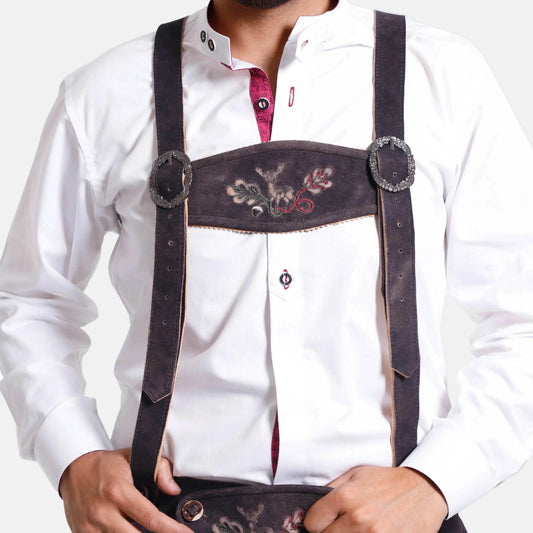 Brown leather suspenders worn over a white shirt with embroidered front panel