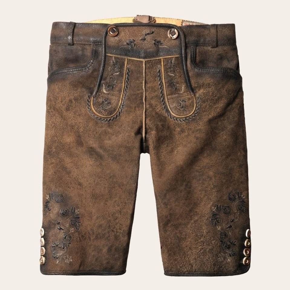 Brown leather lederhosen with suspenders, embossed floral details, and decorative metal buttons